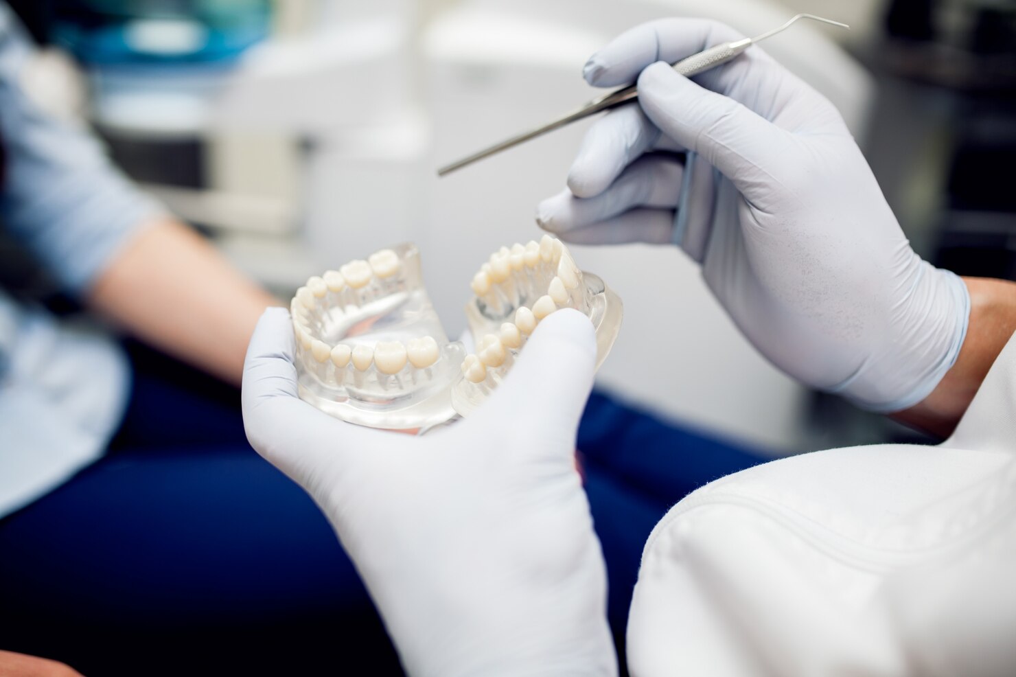 Dentist explaining dental implant treatment using a model of the jaw