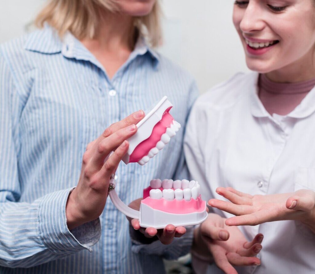 Patient and dentist reviewing a dental model during a denture consultation