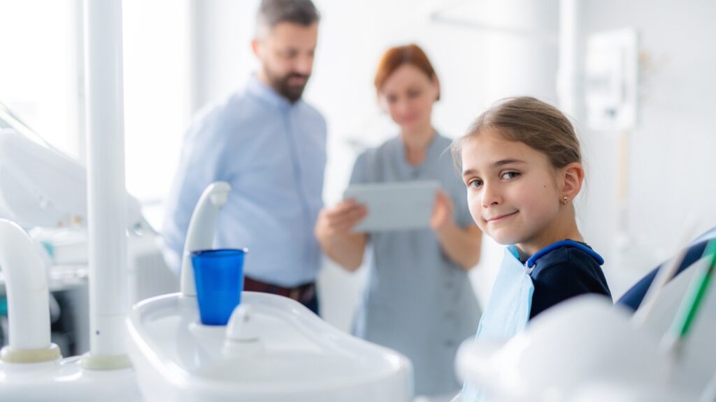 Child smiling in the dental chair at a dental visit