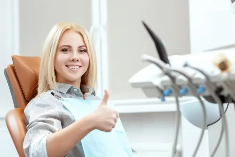 Smiling patient giving a thumbs up in the dental chair